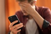 adolescente con mocil y mano en la cabeza